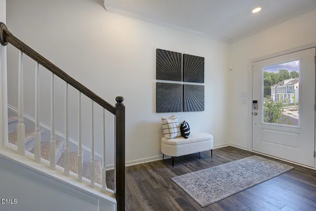 a kitchen with stainless steel appliances granite countertop a stove top oven a sink a dining table and chairs with wooden floor