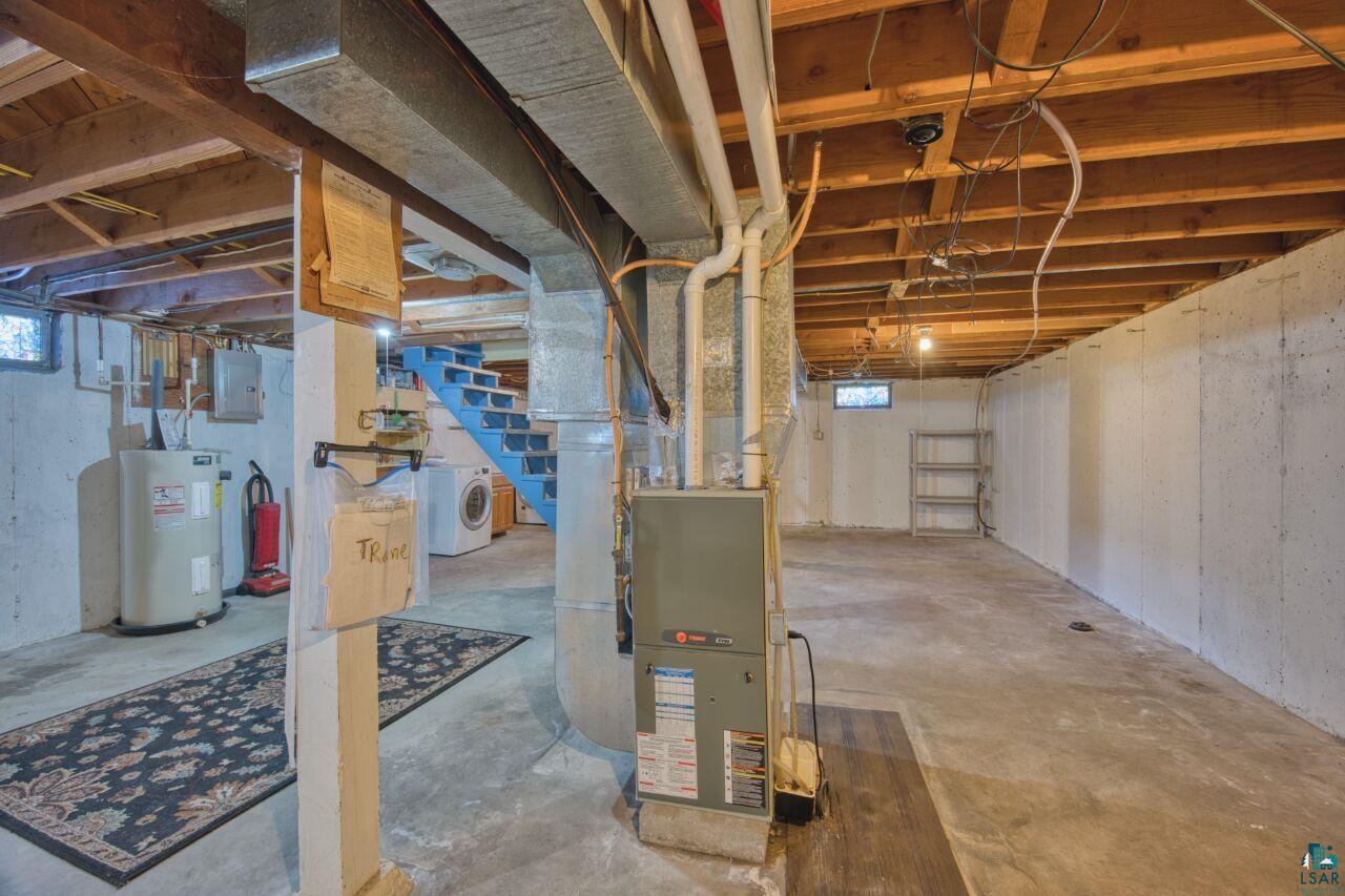 5316 Highway 110 Aurora, MN 55705 - Photo 19 of 35 Basement featuring heating unit, electric water heater, electric panel, washer / dryer, and stairway