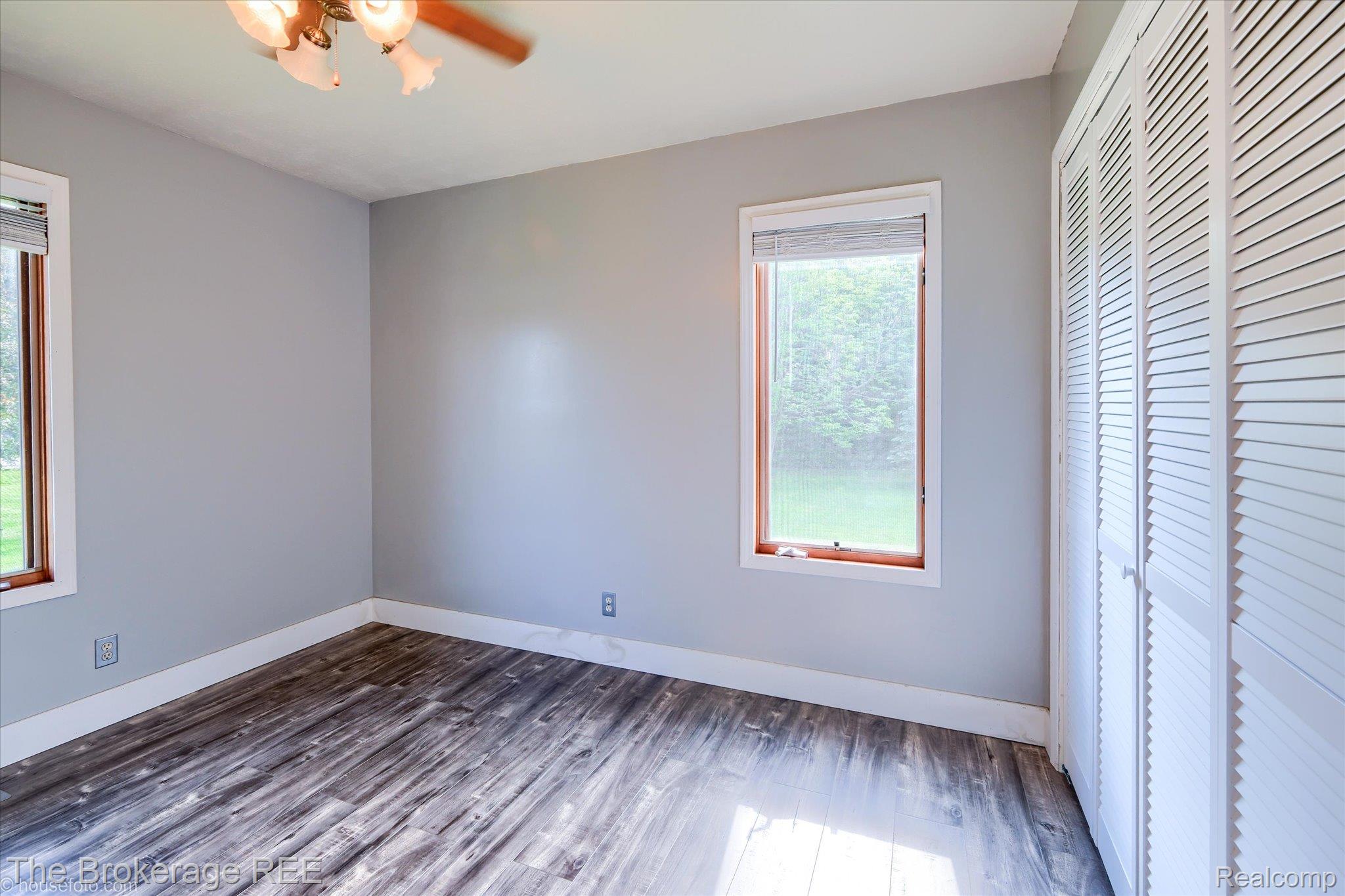 5495 East Coldwater Road Flint, MI 48506 - Photo 28 of 44 Room featuring wood-finish flooring, two windows with wood frames, and a ceiling fan with light fixture
