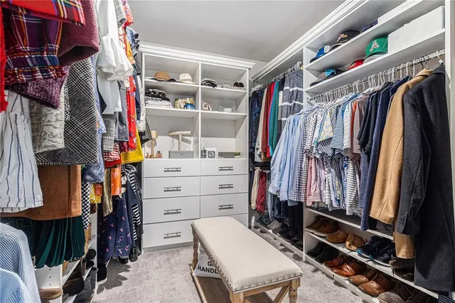 a view of walk in closet with clothes and shoes