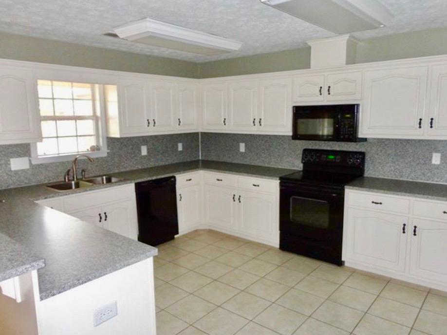 92 McLendon Road Fort Mitchell, AL 36856 - Photo 5 of 16 a kitchen with granite countertop a sink a stove top oven and cabinets