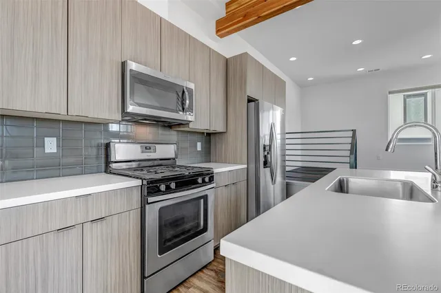 a kitchen with granite countertop a sink and a stove top oven