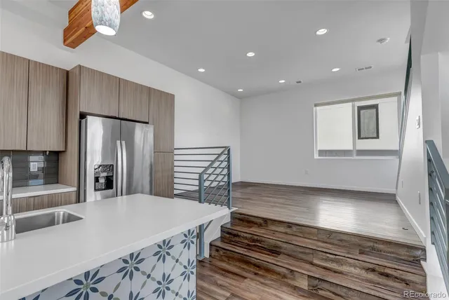 a kitchen with kitchen island a counter top space a sink and refrigerator
