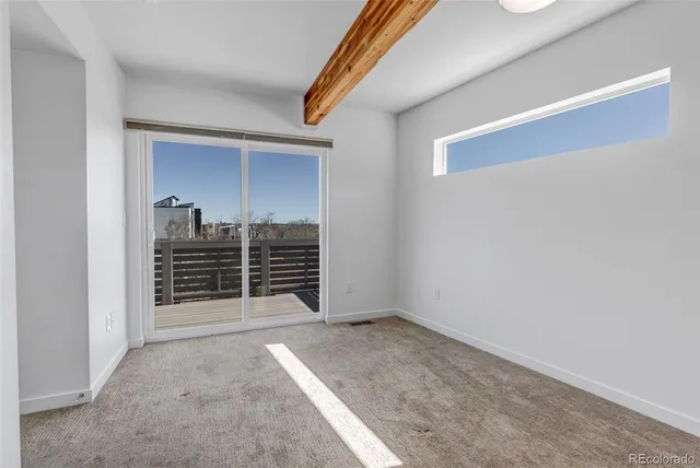 an empty room with large windows and closet