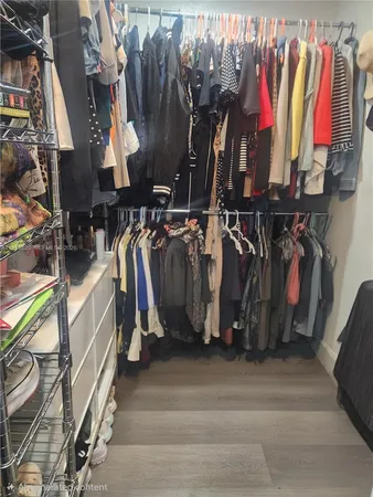 a view of walk in closet with clothes and shoes