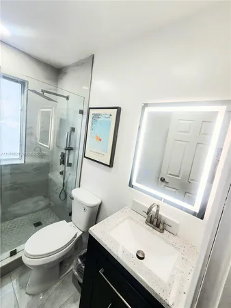 a bathroom with a sink toilet and mirror