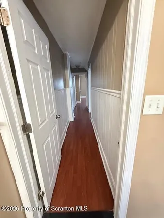 a view of a hallway with wooden floor and staircase