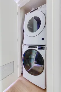 a living room with furniture a rug potted plant and kitchen view