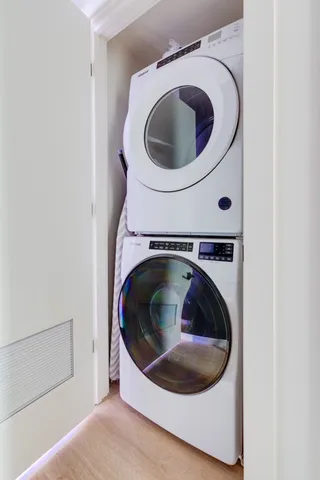 a living room with furniture a rug potted plant and kitchen view