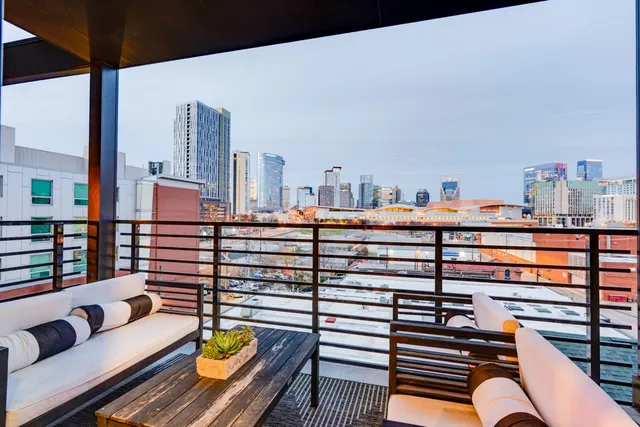 a living room with furniture a potted plant and a projector