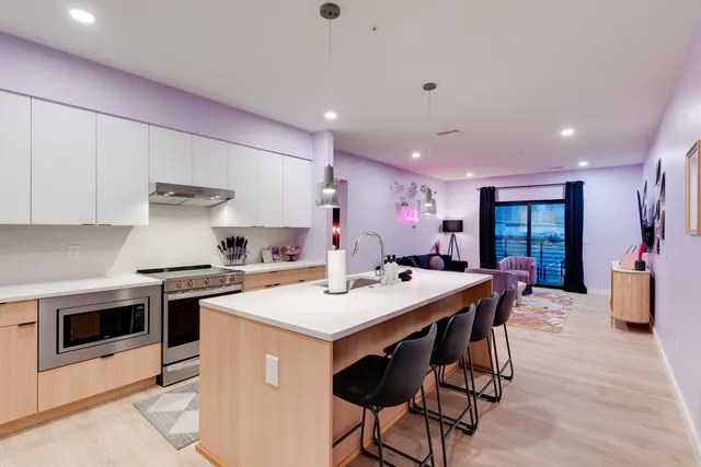 a kitchen with a stove a table and chairs in it