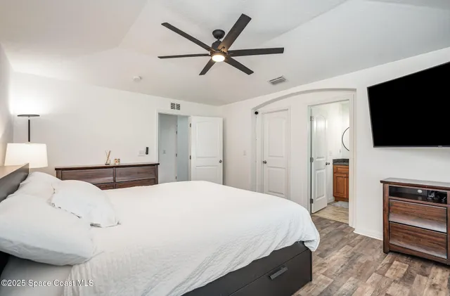 a bedroom with a bed and a flat screen tv