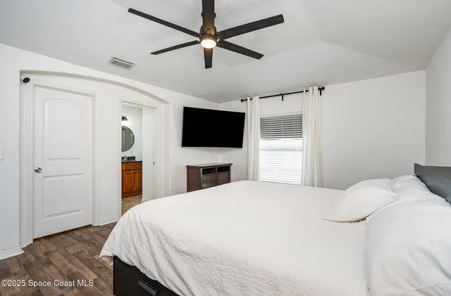 a bedroom with a bed and a flat screen tv