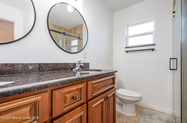 a bathroom with a toilet a sink and mirror