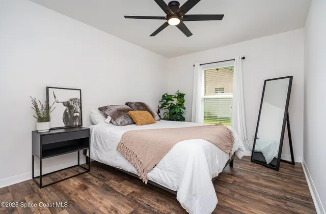 a bedroom with a bed and wooden floor