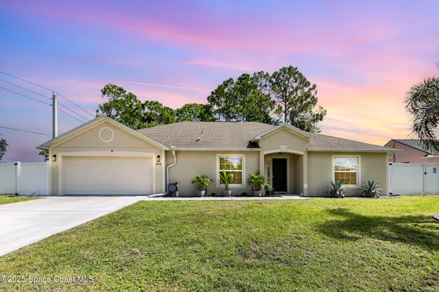 a front view of a house with a garden and yard