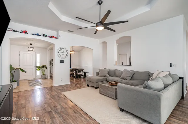a living room with furniture and a wooden floor