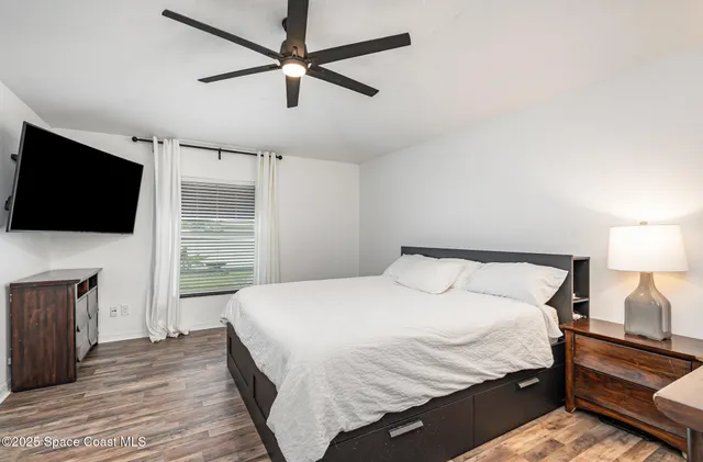 a bedroom with a bed and a flat screen tv