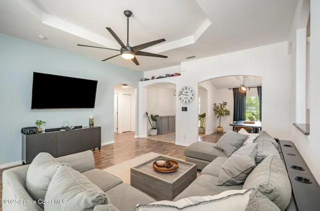 a living room with furniture a flat screen tv and a large window
