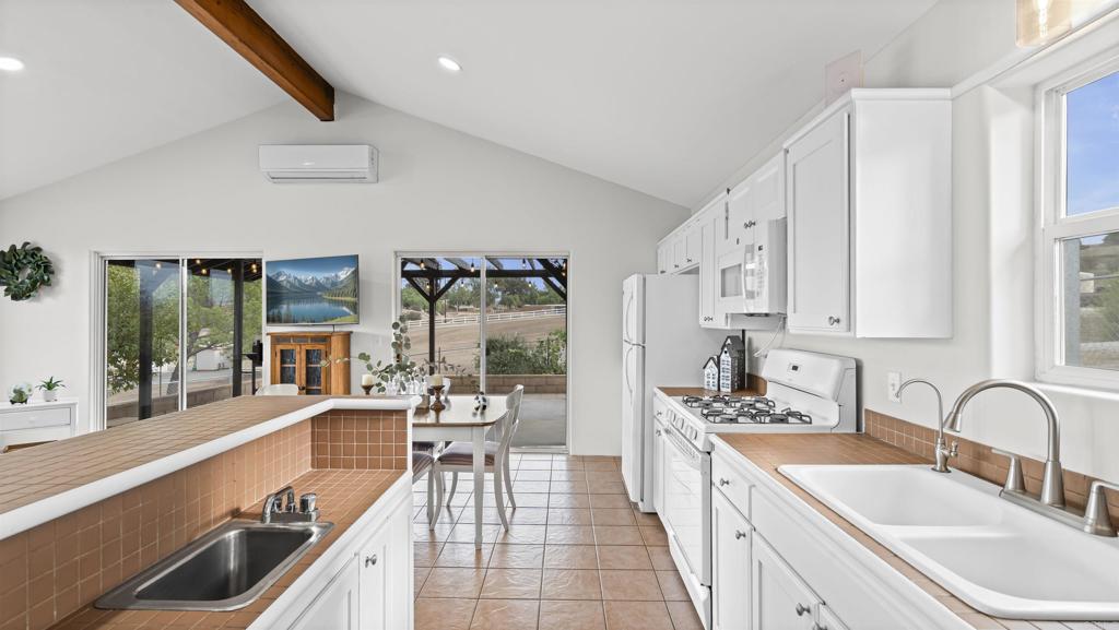 39260 Grassy Road Temecula, CA 92592 - Photo 11 of 53 a large kitchen with kitchen island a large window cabinets a sink and stainless steel appliances