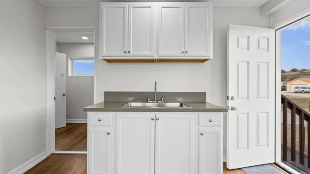 a kitchen with granite countertop a sink and cabinets