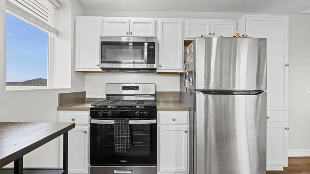a kitchen with stainless steel appliances a refrigerator stove and microwave