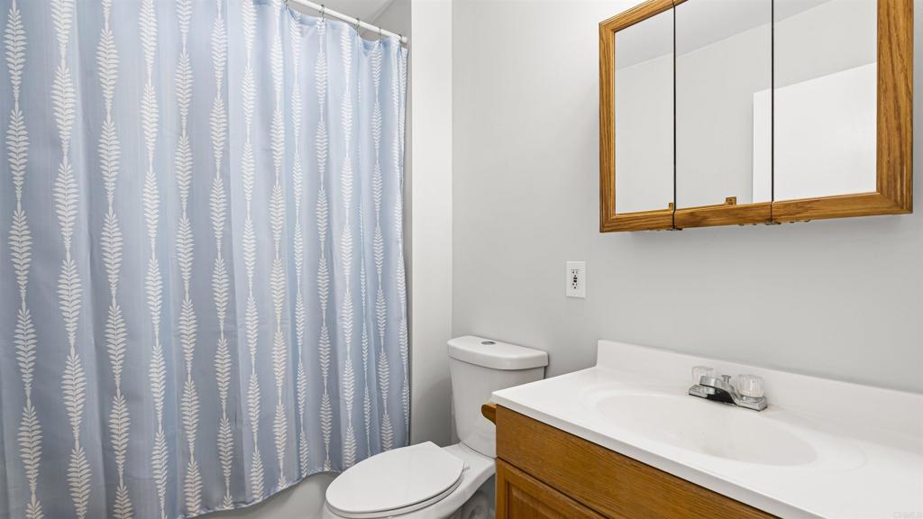 39260 Grassy Road Temecula, CA 92592 - Photo 30 of 50 a bathroom with a sink a toilet and shower curtain