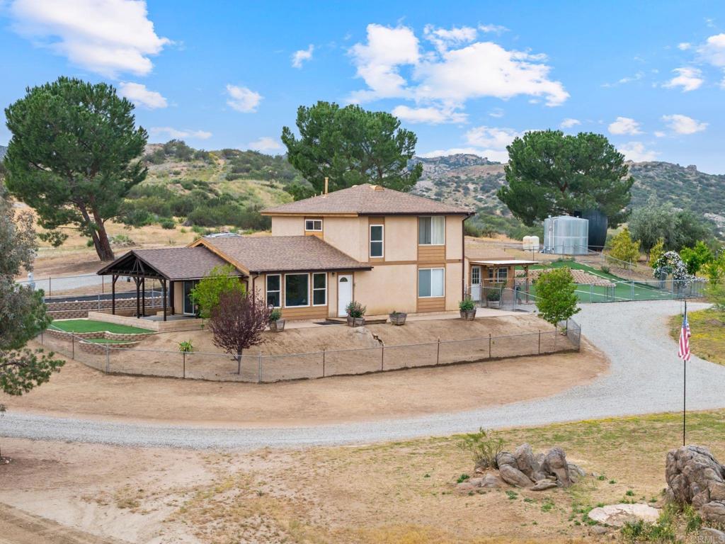 39260 Grassy Road Temecula, CA 92592 - Photo 47 of 53 a view of a white house with a yard plants and large tree