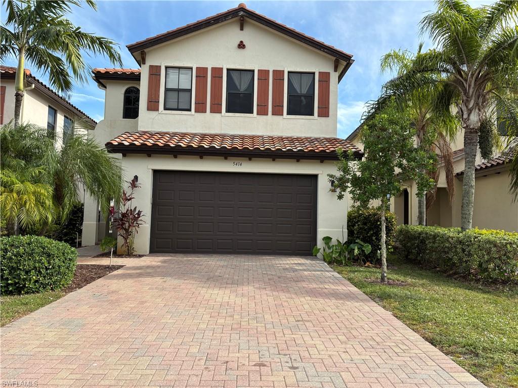 Mediterranean / spanish-style house with stucco siding, decorative driveway, an attached garage, and a tile roof