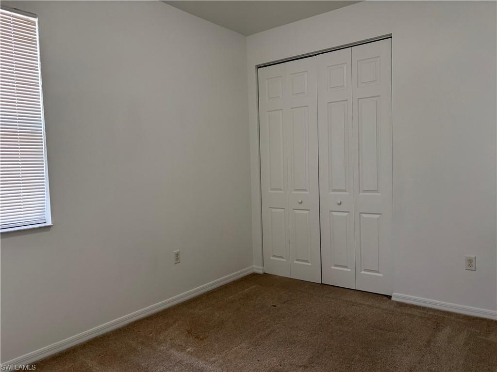 5414 Ferris Avenue Ave Maria, FL 34142 - Photo 12 of 15 Unfurnished bedroom featuring dark colored carpet and a closet