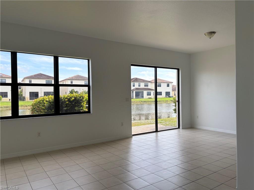5414 Ferris Avenue Ave Maria, FL 34142 - Photo 2 of 15 Unfurnished room featuring light tile patterned floors, a water view, and a residential view