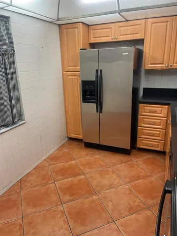 a kitchen with granite countertop a refrigerator a sink and dishwasher