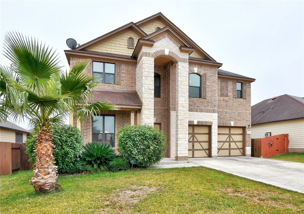 356 Matthews Kyle, TX 78640 - Photo 23 of 30 A traditional brick residence, graced with a palm tree and manicured shrubs, presents a welcoming facade.