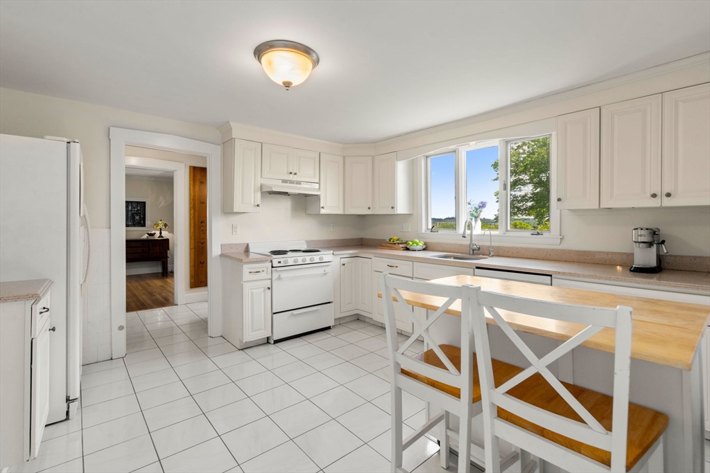 107 Stoneleigh Road Watertown, MA 02472 - Photo 17 of 42 a kitchen with a stove a sink and a refrigerator
