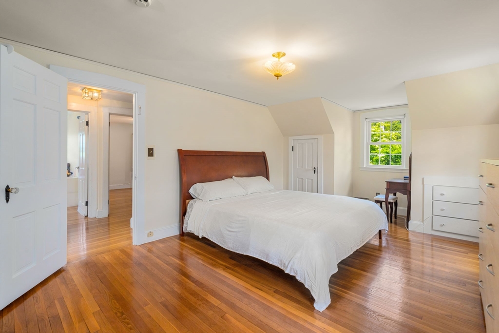 107 Stoneleigh Road Watertown, MA 02472 - Photo 29 of 42 a bedroom with a bed and wooden floor