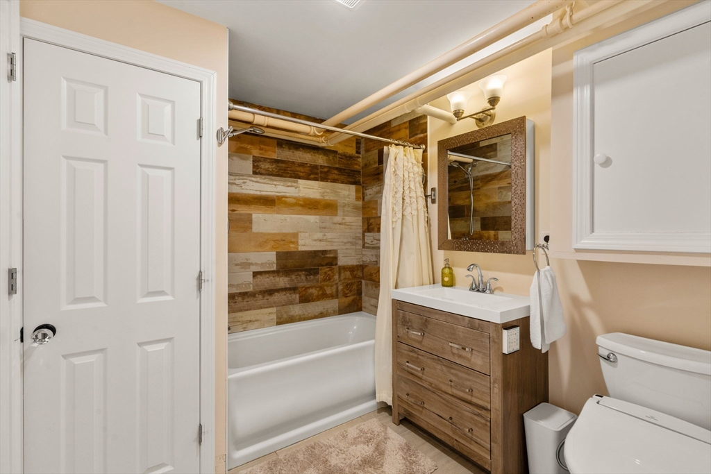 107 Stoneleigh Road Watertown, MA 02472 - Photo 39 of 42 a bathroom with a sink a toilet and shower