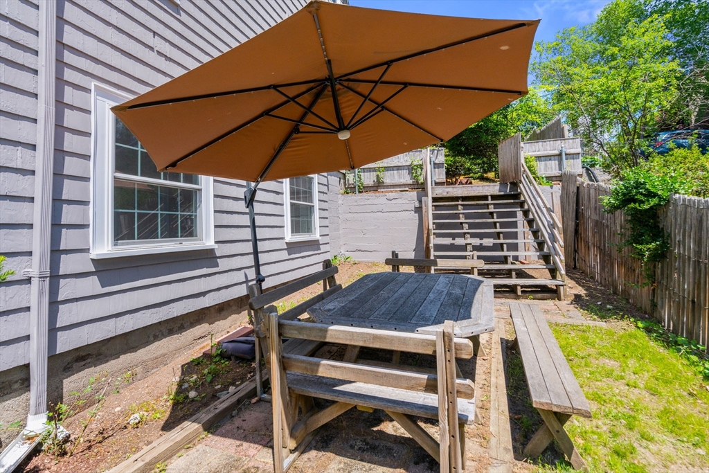 107 Stoneleigh Road Watertown, MA 02472 - Photo 8 of 42 a view of a patio with table and chairs under an umbrella