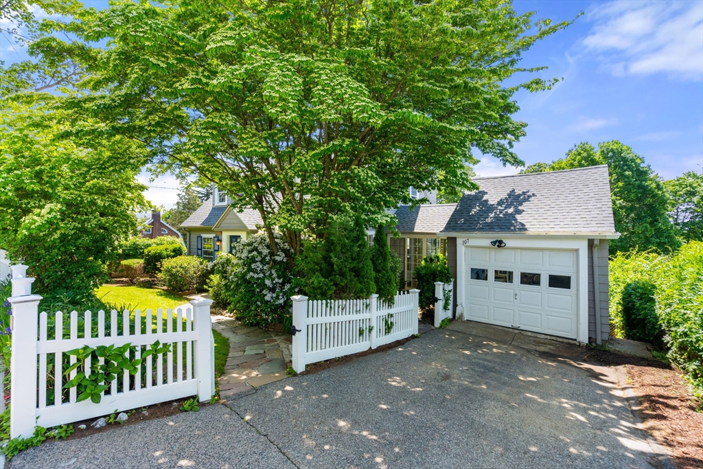 107 Stoneleigh Road Watertown, MA 02472 - Photo 10 of 42 a view of a house with a small yard and wooden fence