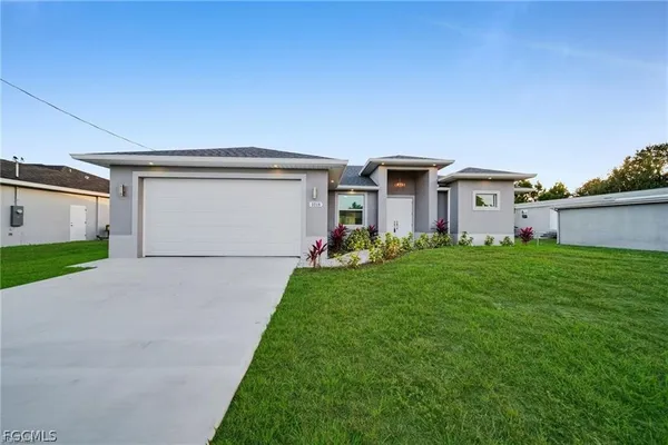 a view of a house with a yard and garage