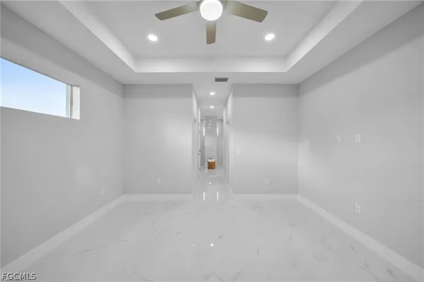 an empty room with a window and a fan