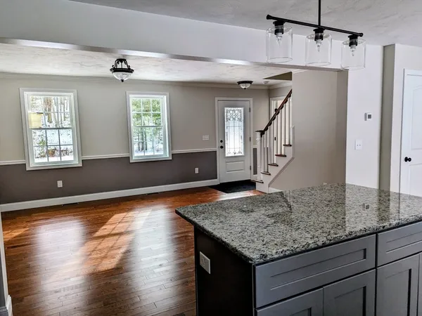 a kitchen with granite countertop wooden cabinets a sink and dishwasher next to a window