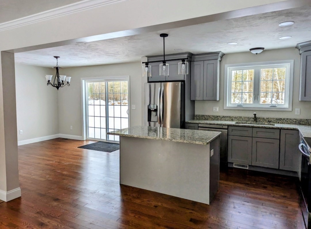 508 Old County Road Holland, MA 01521 - Photo 7 of 42 a kitchen with stainless steel appliances granite countertop a refrigerator a sink dishwasher a stove and white countertops with wooden floor