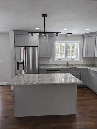 a kitchen with kitchen island granite countertop a sink window and refrigerator