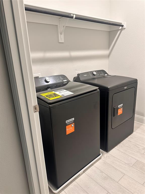 824 Heart Reef Road Plano, TX 75075 - Photo 15 of 19 Washer and dryer units with a wall-mounted shelf and hanging rod