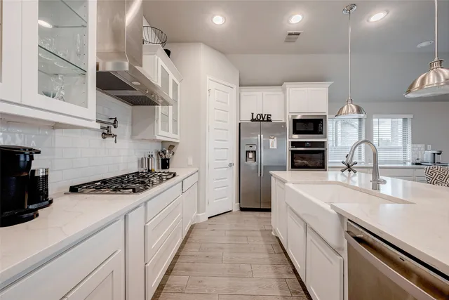 a kitchen with stainless steel appliances a sink stove and refrigerator