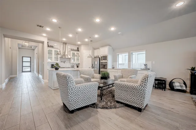 a living room with furniture and a wooden floor