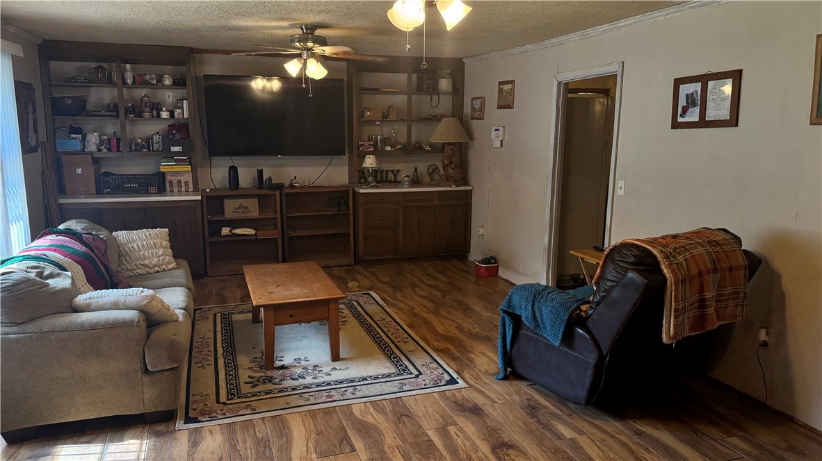 101 Due West Road Belton, SC 29627 - Photo 4 of 22 An inviting family room offers built-in shelving, a ceiling fan, and durable wood flooring.