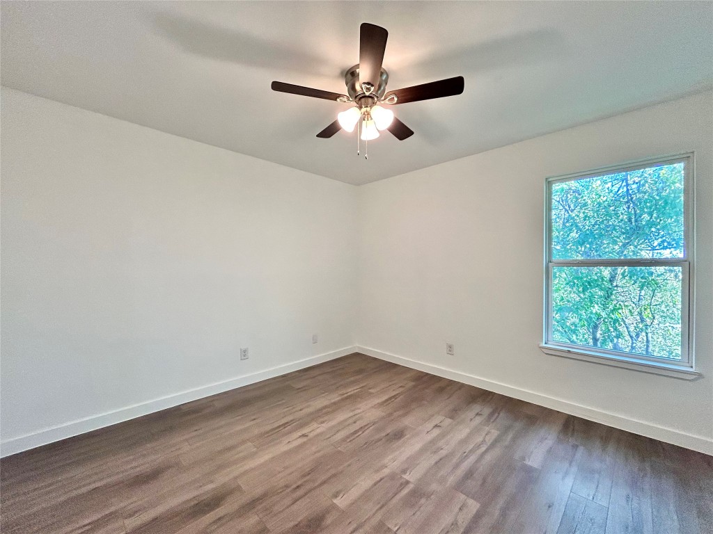6409 Burns Street, Unit 305 Austin, TX 78752 - Photo 14 of 19 an empty room with wooden floor fan and windows