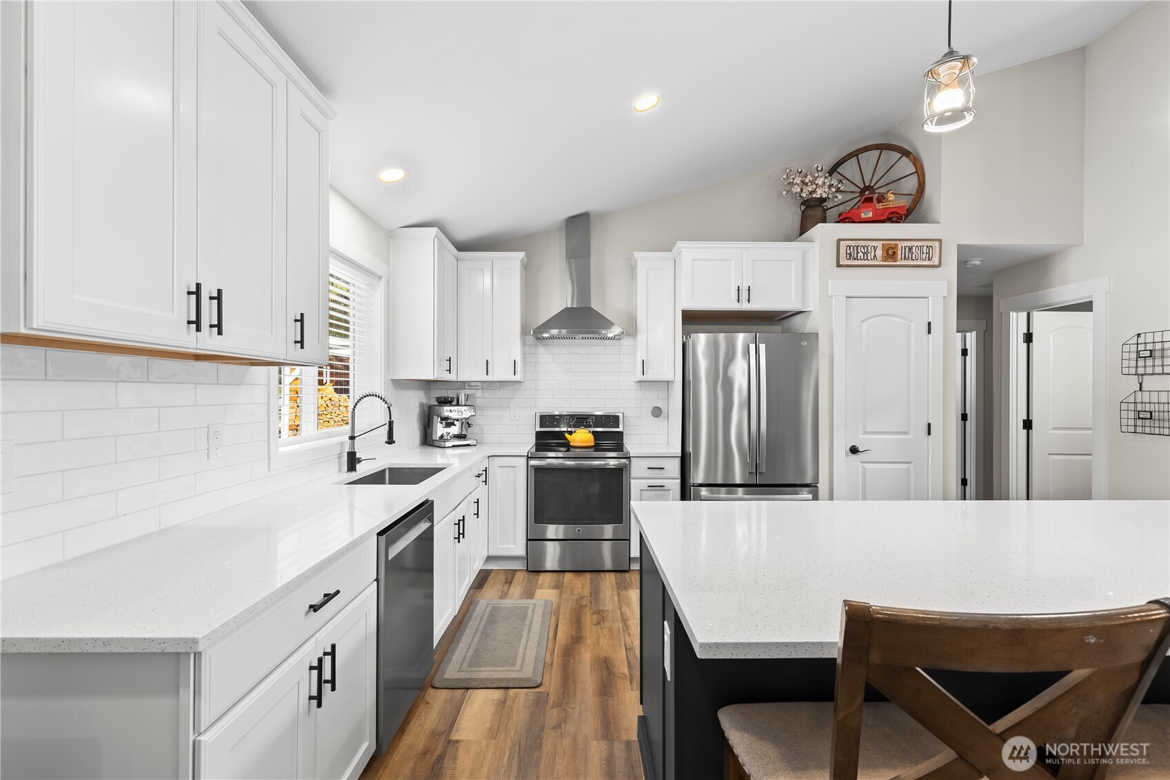 971 Old Cedars Road Cle Elum, WA 98922 - Photo 10 of 39 a kitchen with stainless steel appliances a stove a sink a refrigerator and white cabinets with wooden floor