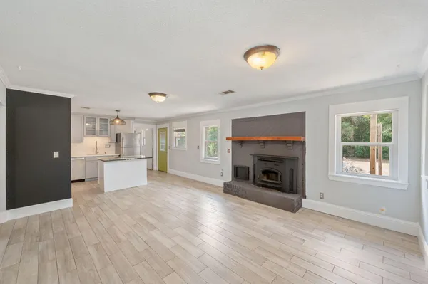 a view of a livingroom with wooden floor and a fireplace